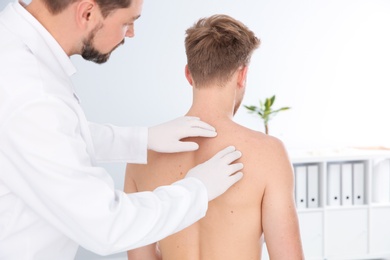 Photo of Dermatologist examining patient's birthmark in clinic