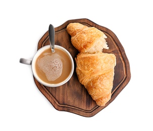 Photo of Wooden board with tasty croissant and cup of coffee on white background, top view