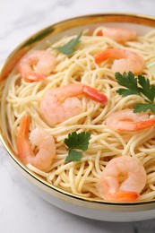 Photo of Tasty spaghetti with shrimps and parsley in bowl on white table, closeup