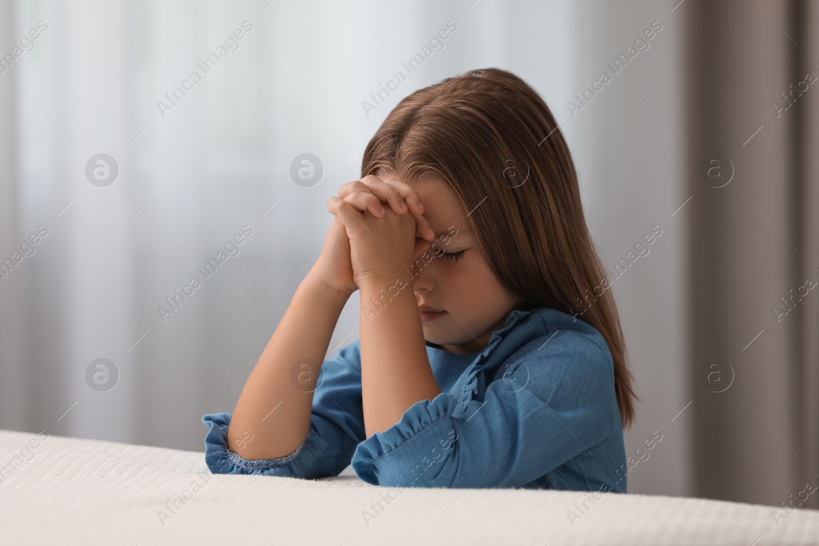 Photo of Cute little girl saying bedtime prayer at home