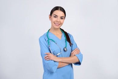 Photo of Portrait of medical assistant with stethoscope on light background