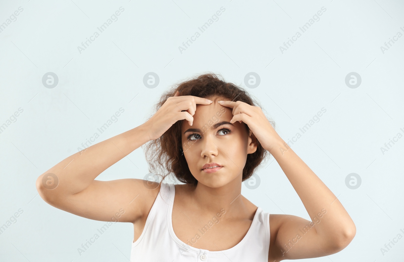 Photo of Beautiful young woman with acne problem on light background