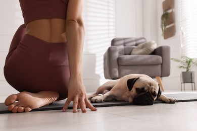 Woman with dog practicing yoga at home, closeup