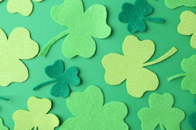 St. Patrick's day. Decorative clover leaves on green background, flat lay