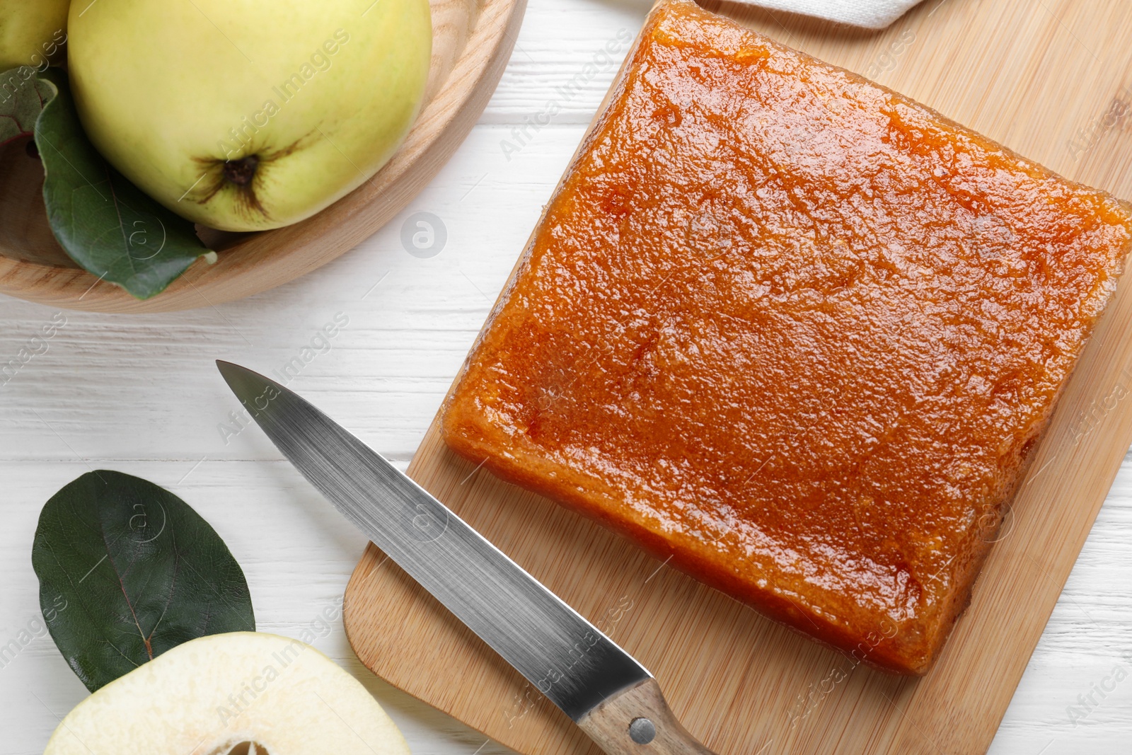 Photo of Delicious quince paste and fresh fruit on white wooden table, flat lay