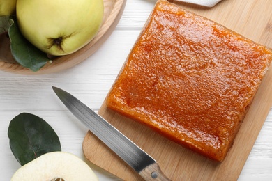 Delicious quince paste and fresh fruit on white wooden table, flat lay