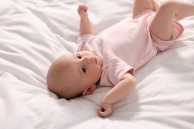 Cute little baby lying on white sheets