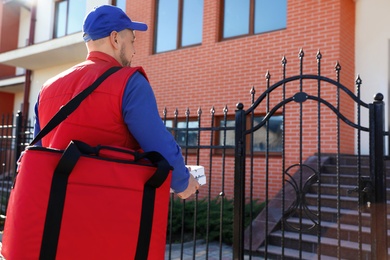 Male courier delivering food in city on sunny day