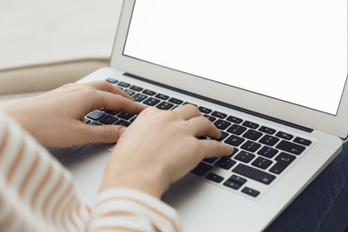 Woman working on modern laptop at home, closeup