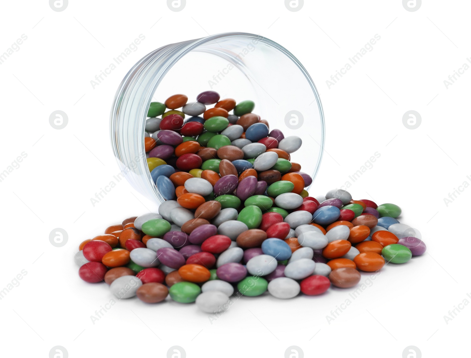 Photo of Delicious bright candies scattered from overturned glass isolated on white