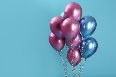 Photo of Bunch of bright balloons on color background. Space for text