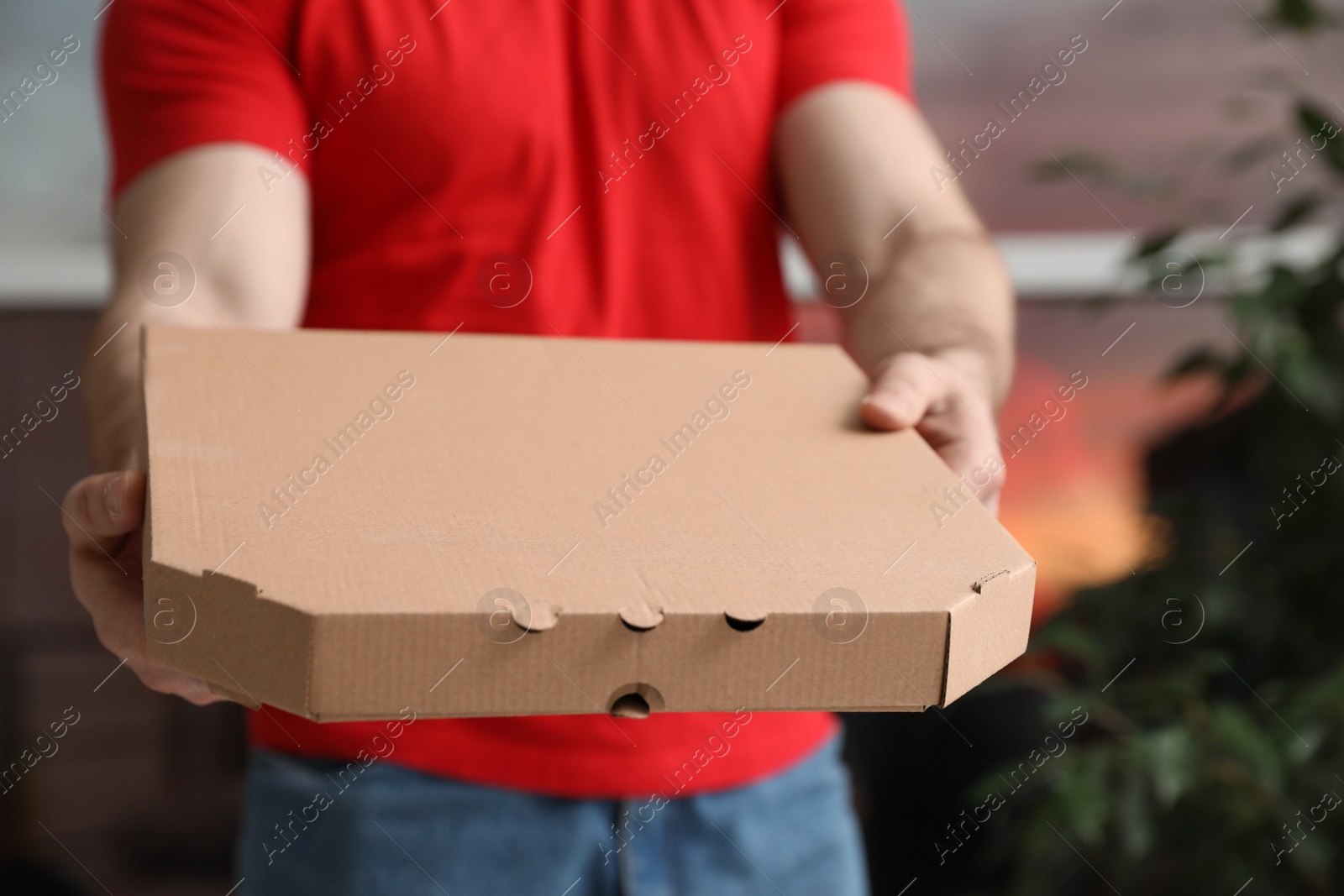 Photo of Courier with pizza box on blurred background, closeup. Space for text