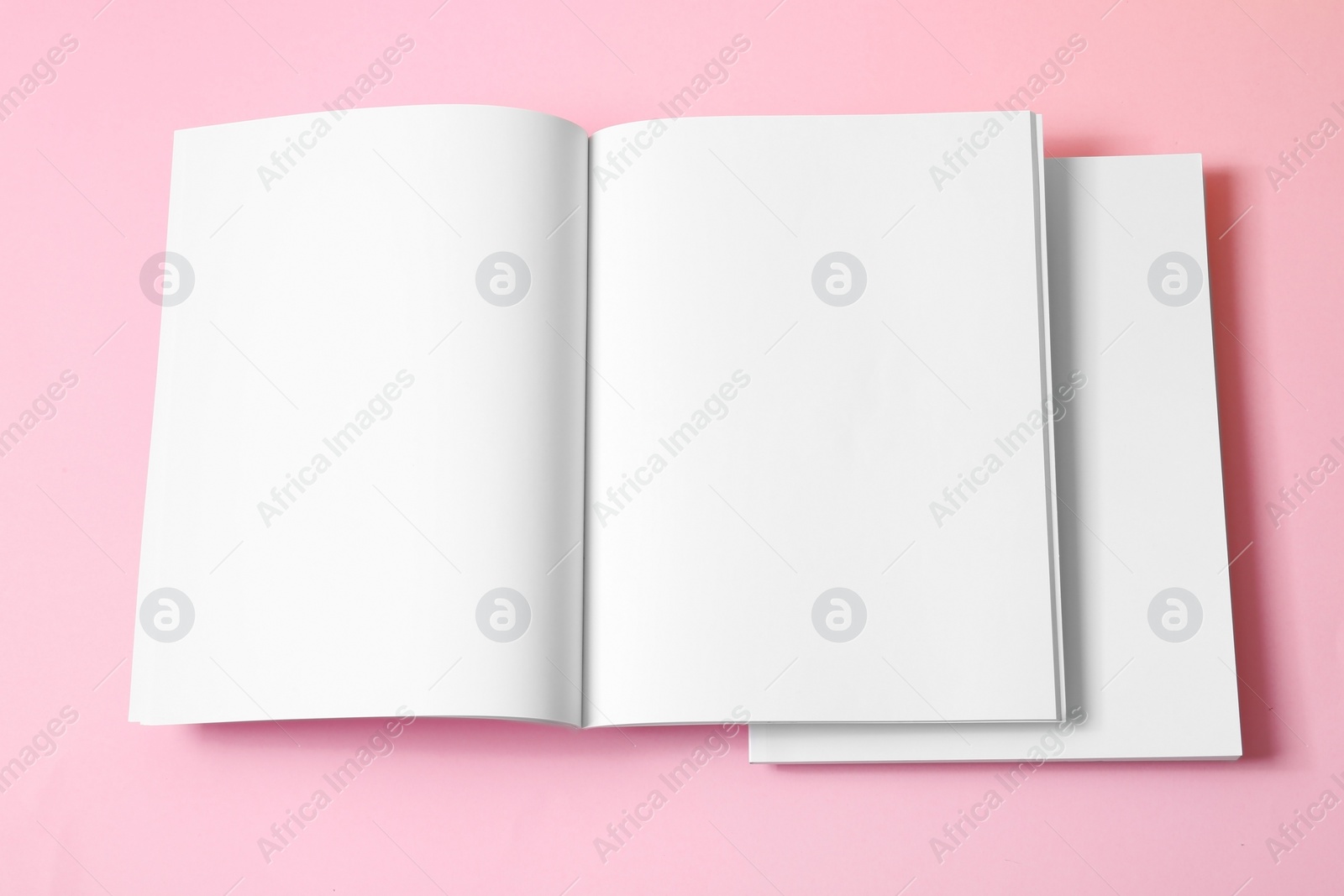 Photo of Empty book pages on pink background, top view. Mockup for design