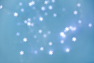 Photo of Beautiful snowflake shaped lights on light blue background