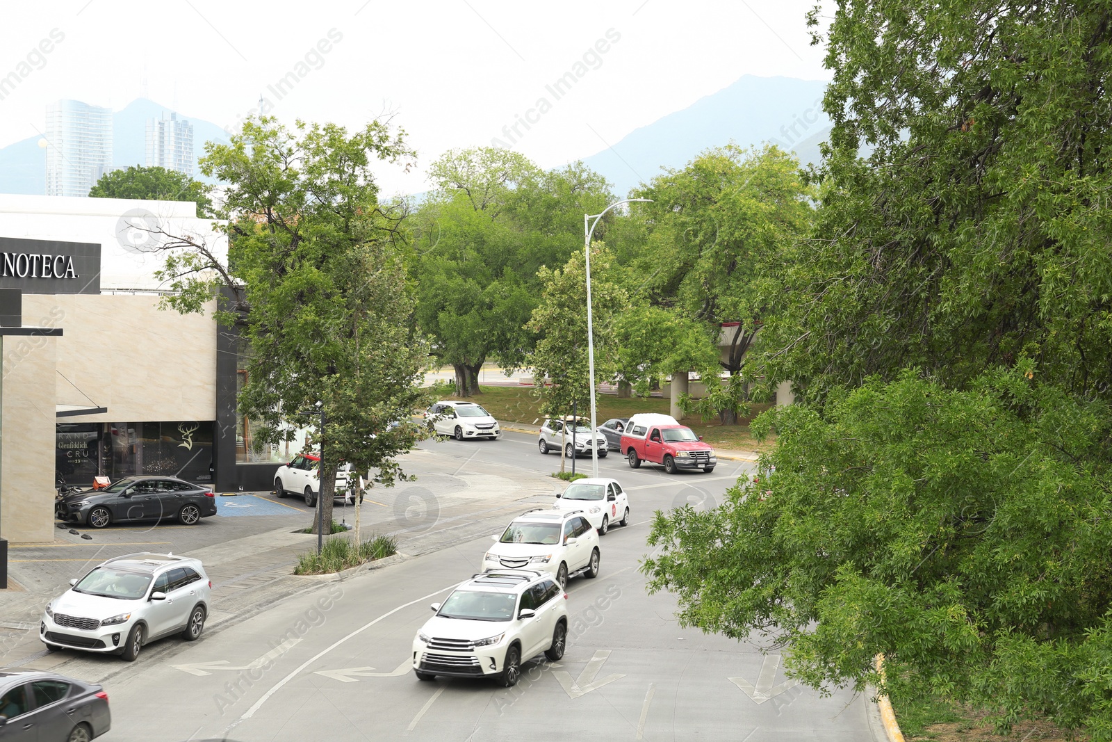 Photo of Mexico, San Pedro Garza Garcia - August 26, 2022: Modern building and cars near on city street