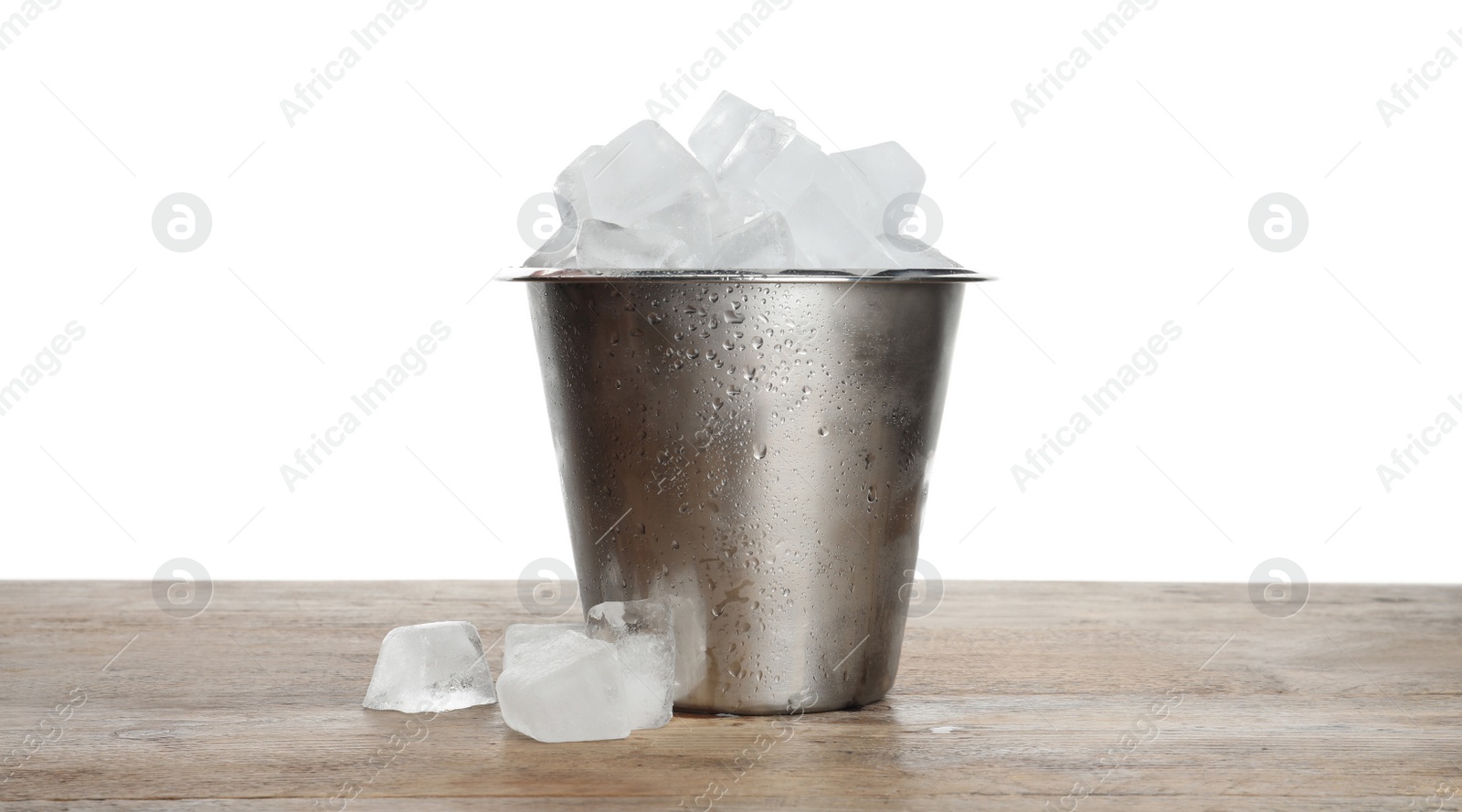 Photo of Metal bucket with ice cubes on wooden table against white background