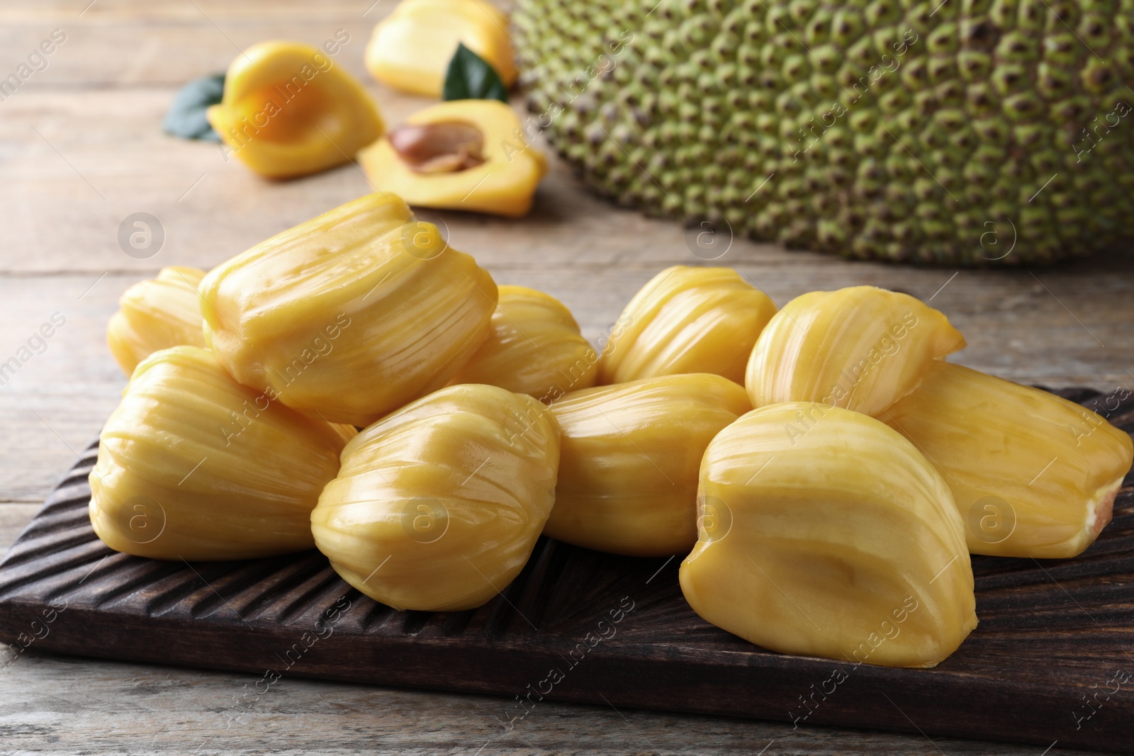 Photo of Fresh exotic jackfruit bulbs on wooden table