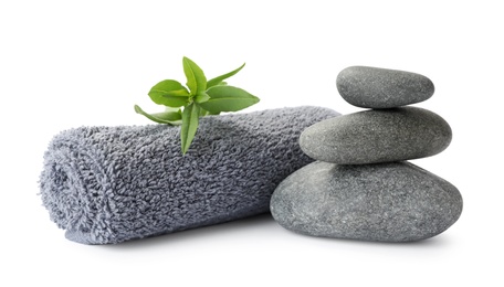 Photo of Spa stones, green leaves and towel on white background