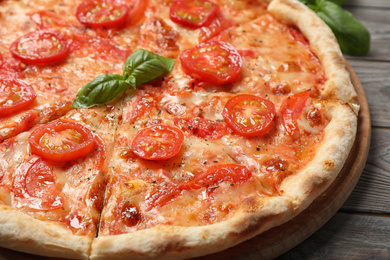 Photo of Delicious pizza Margherita on wooden table, closeup view