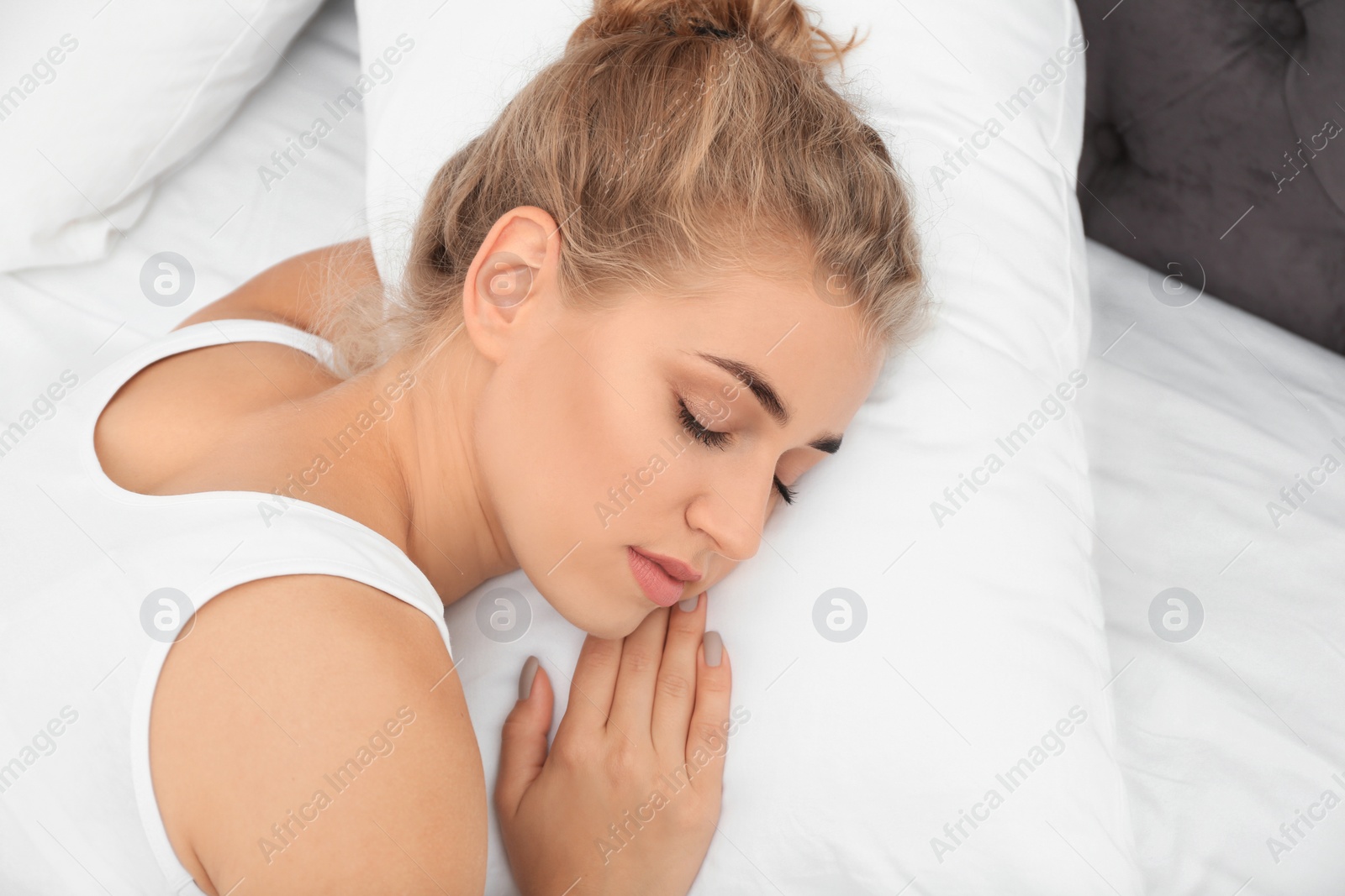 Photo of Beautiful woman sleeping with comfortable pillow on bed at home