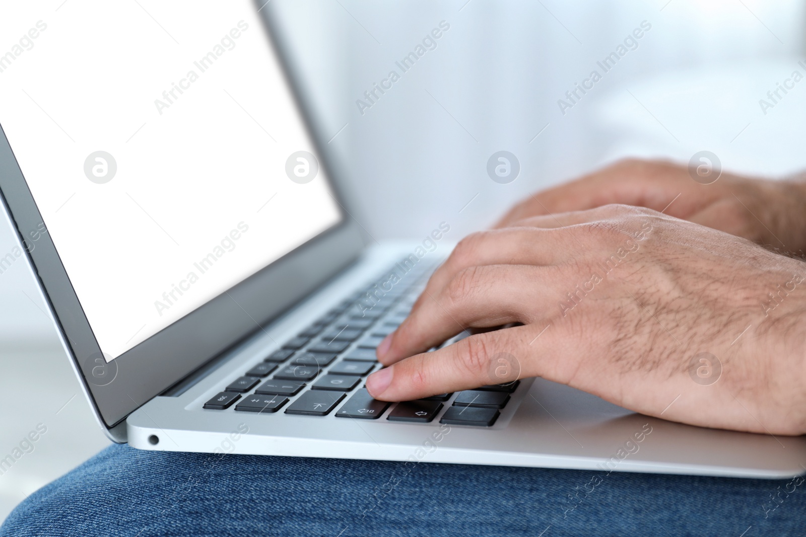 Photo of Man working on modern laptop at home, closeup