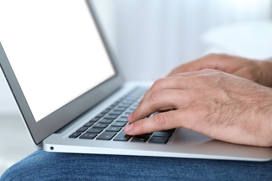 Photo of Man working on modern laptop at home, closeup