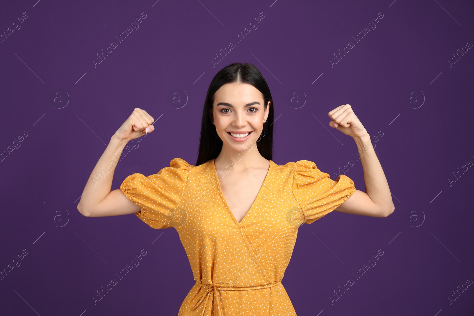 Photo of Strong woman as symbol of girl power on purple background. 8 March concept