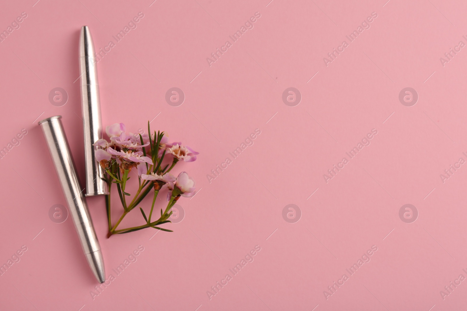 Photo of Bullets and beautiful flowers on pink background, flat lay. Space for text