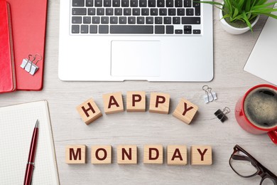 Photo of Cubes with message Happy Monday, office stationery and cup of coffee on wooden desk, flat lay