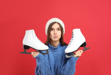 Photo of Pretty woman with ice skates on red background
