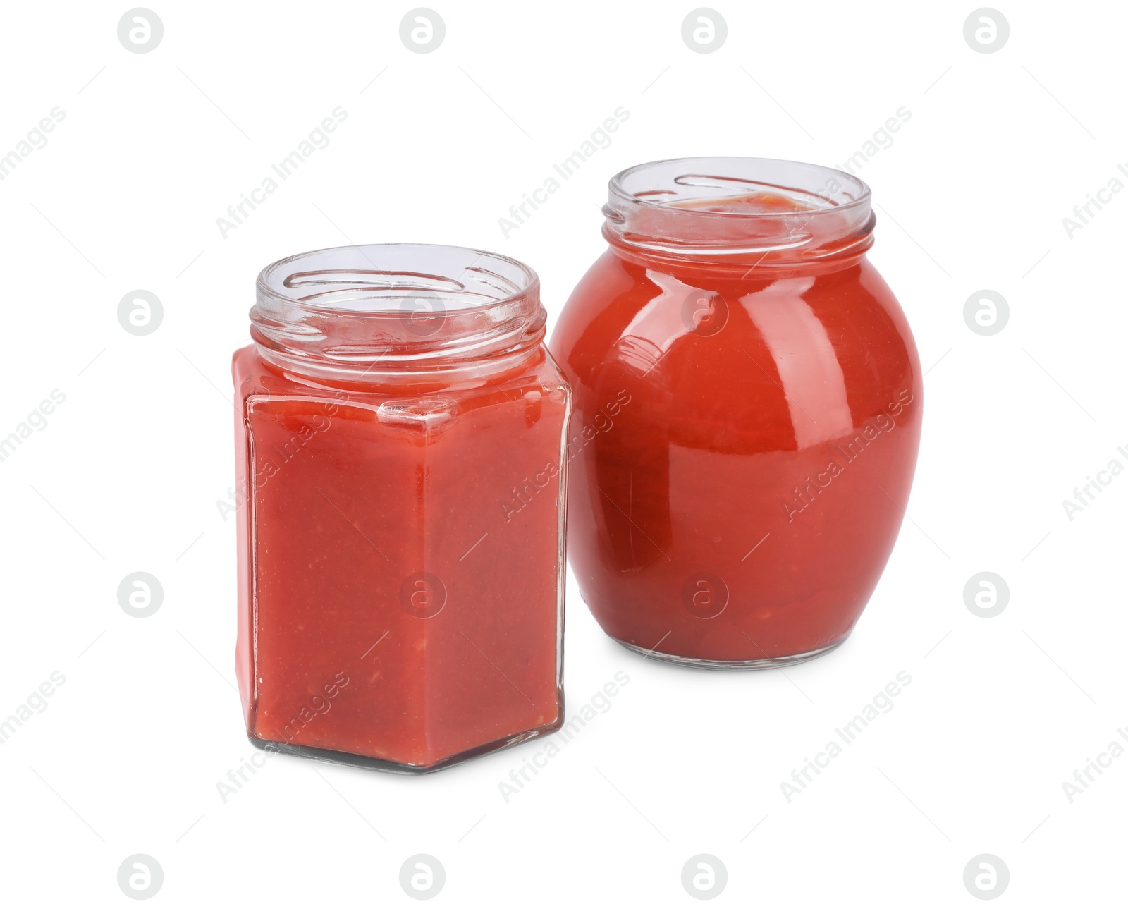 Photo of Organic ketchup in glass jars isolated on white. Tomato sauce