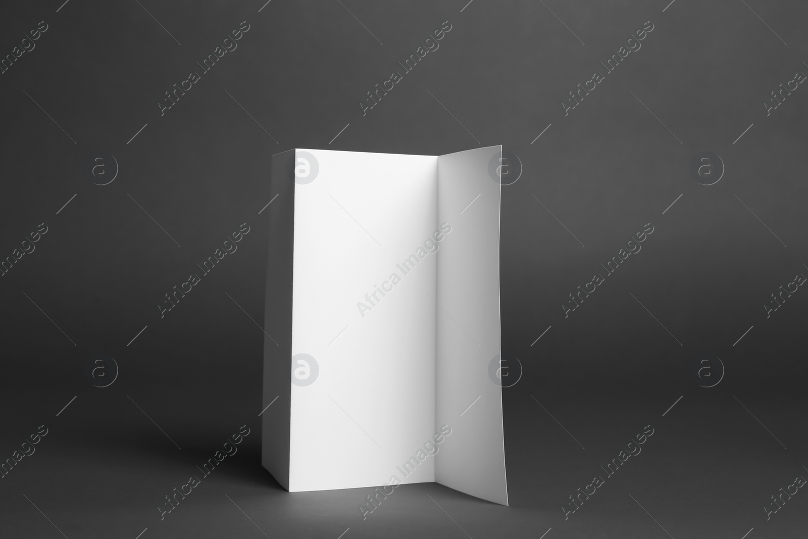 Photo of Blank brochure on dark grey background. Mock up for design