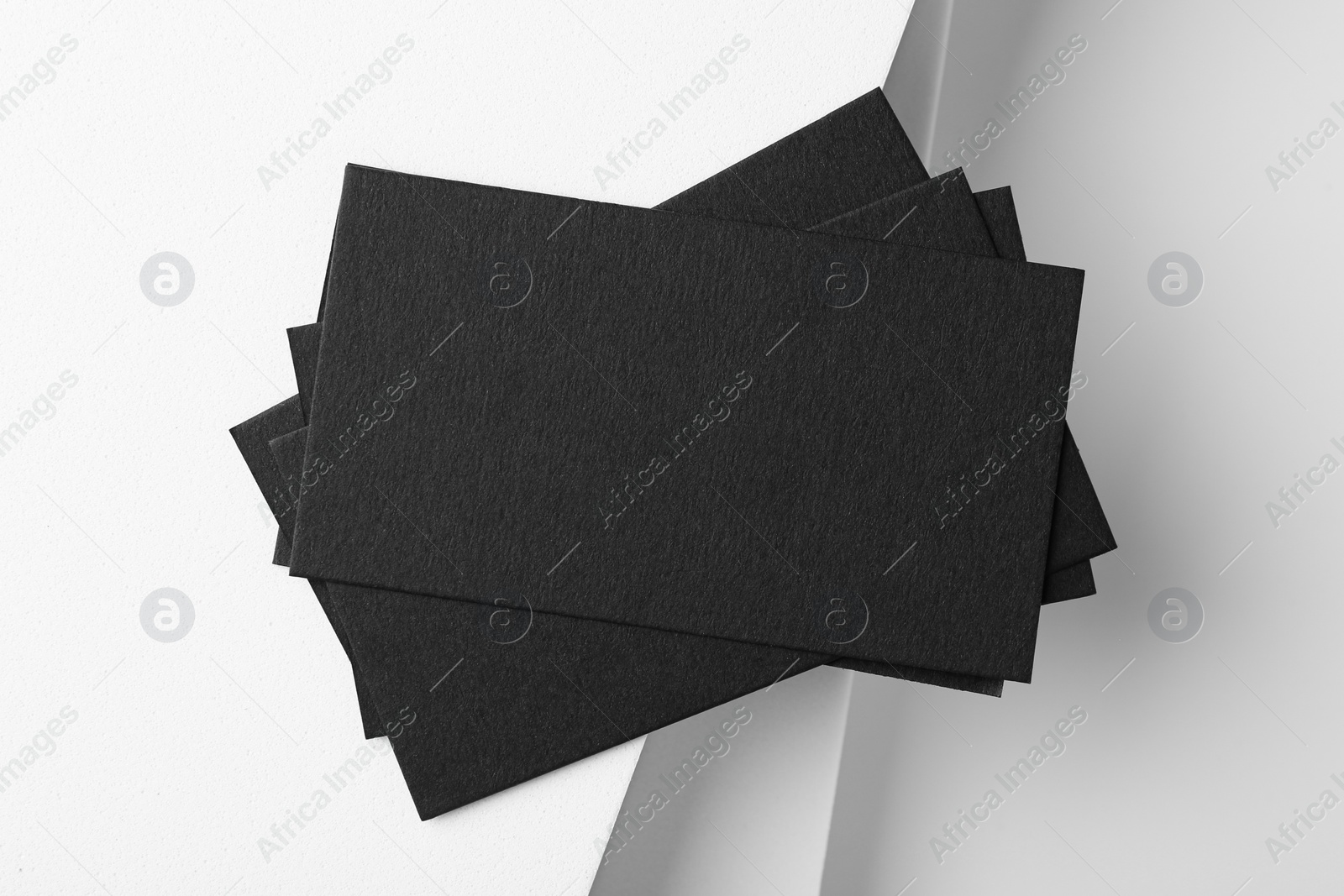 Photo of Blank black business cards on light background, top view. Mockup for design