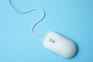 Photo of Wired computer mouse on light blue background, top view