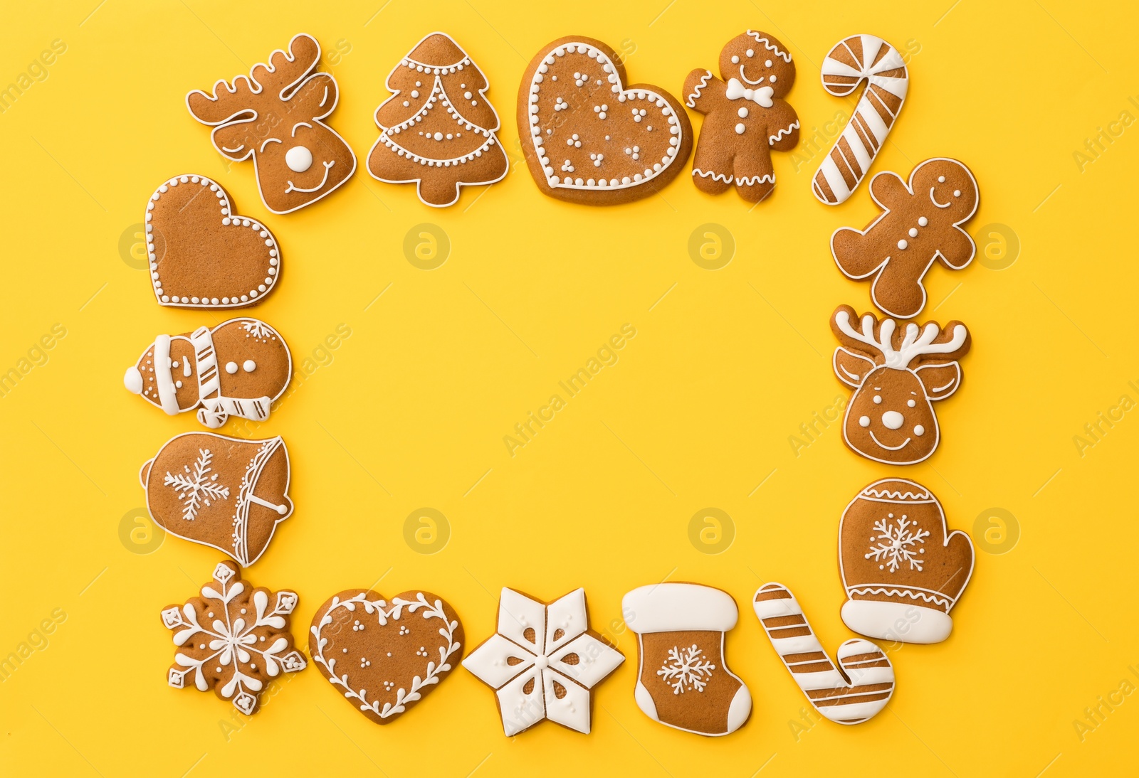 Photo of Frame made with different Christmas gingerbread cookies on yellow background, flat lay. Space for text