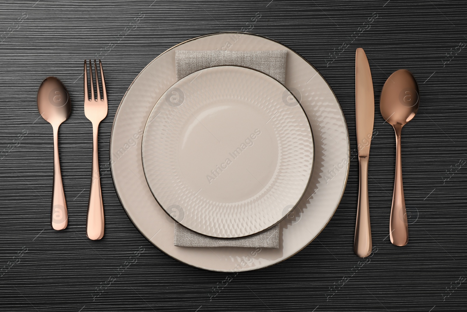 Photo of Stylish setting with cutlery and plates on black wooden table, flat lay