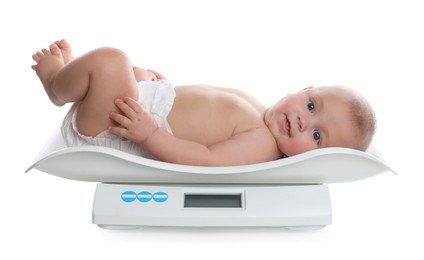 Cute little baby lying on scales against white background