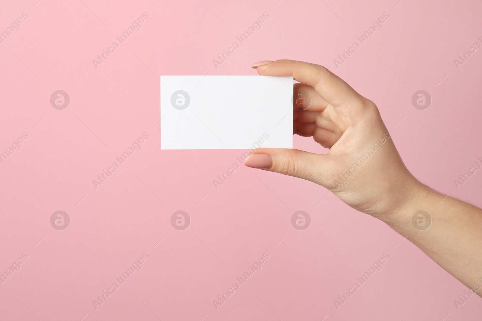 Photo of Woman holding blank business card on pink background, closeup. Mockup for design