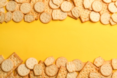 Photo of Delicious crackers on yellow background, flat lay. Space for text