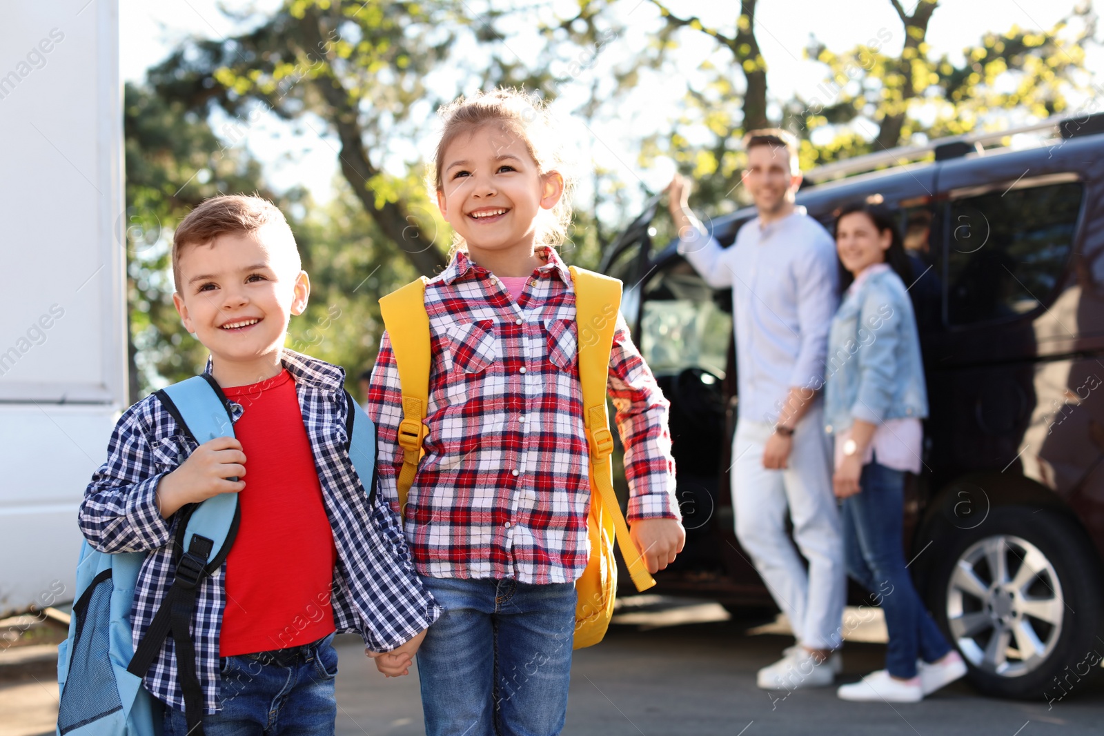 Photo of Young parents seeing their little children off to school