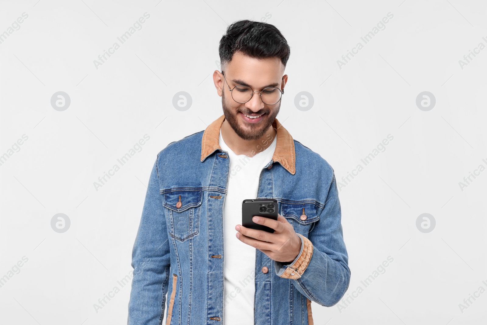 Photo of Happy young man using smartphone on white background