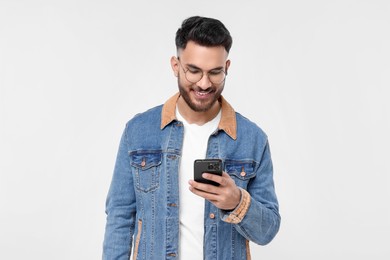 Photo of Happy young man using smartphone on white background