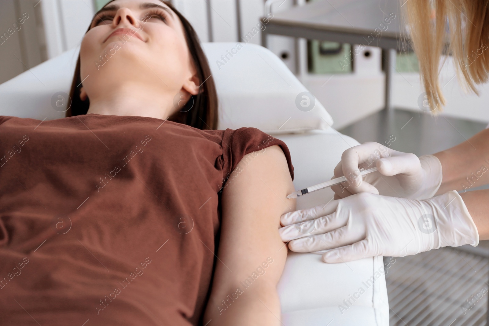 Photo of Doctor vaccinating female patient in clinic