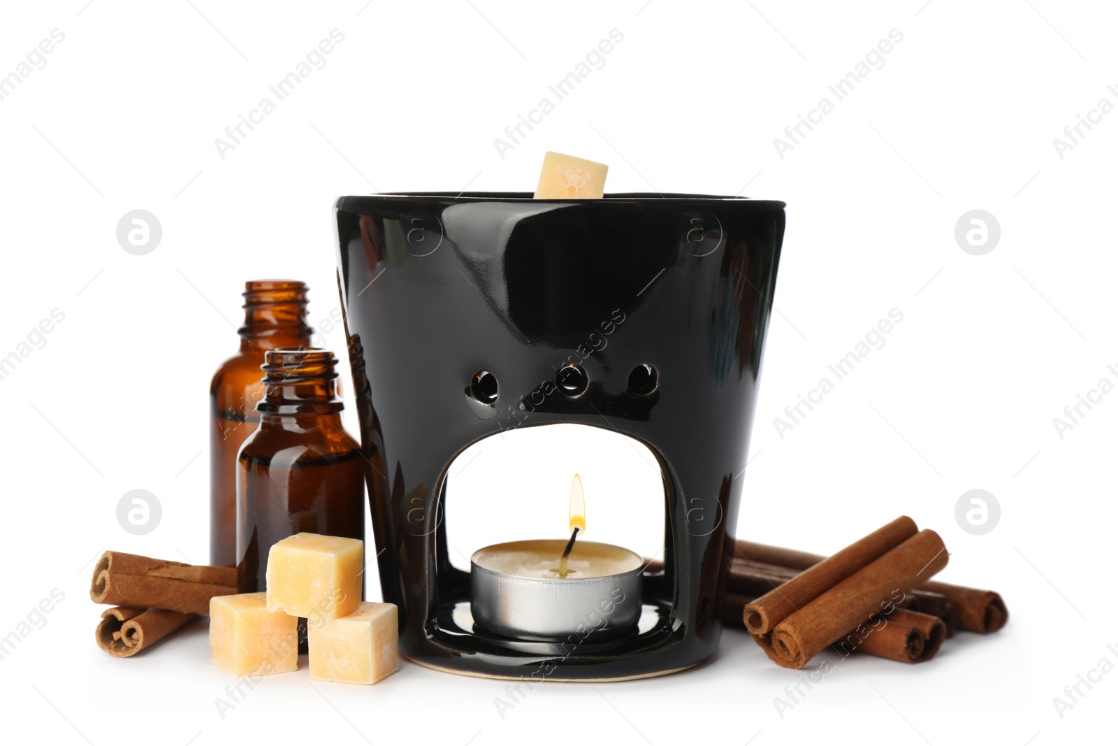 Photo of Stylish aroma lamp with essential wax cubes, oil and cinnamon on white background
