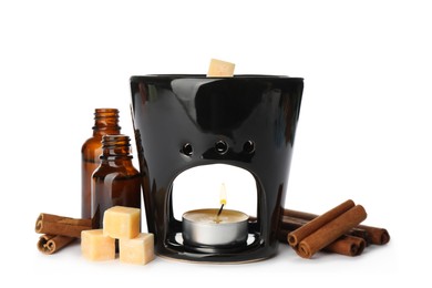 Stylish aroma lamp with essential wax cubes, oil and cinnamon on white background