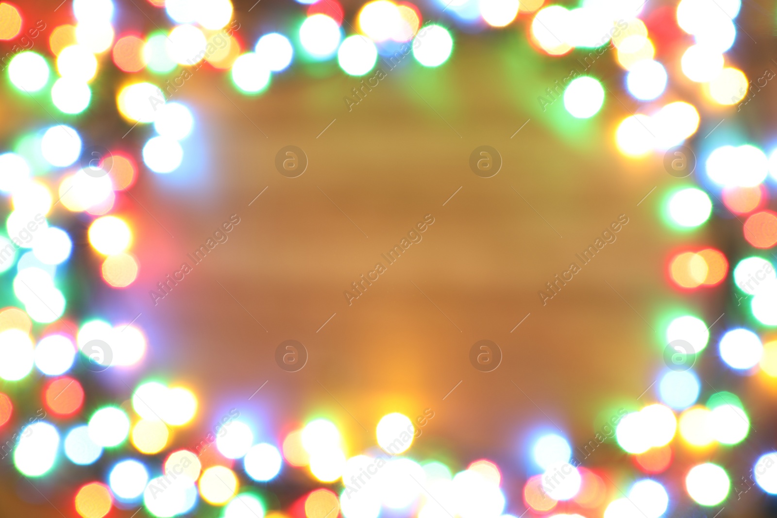 Photo of Blurred view of frame made with colorful Christmas lights on light background. Bokeh effect