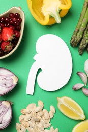 Paper cutout of kidney and different healthy products on green background, flat lay