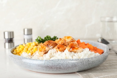 Photo of Plate of boiled rice with vegetables and meat on table