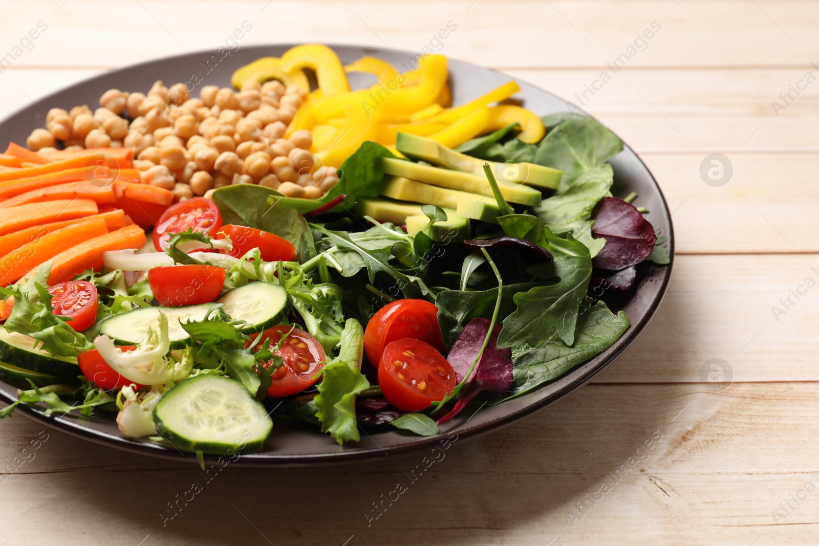 Photo of Balanced diet and vegetarian foods. Plate with different delicious products on wooden table, closeup