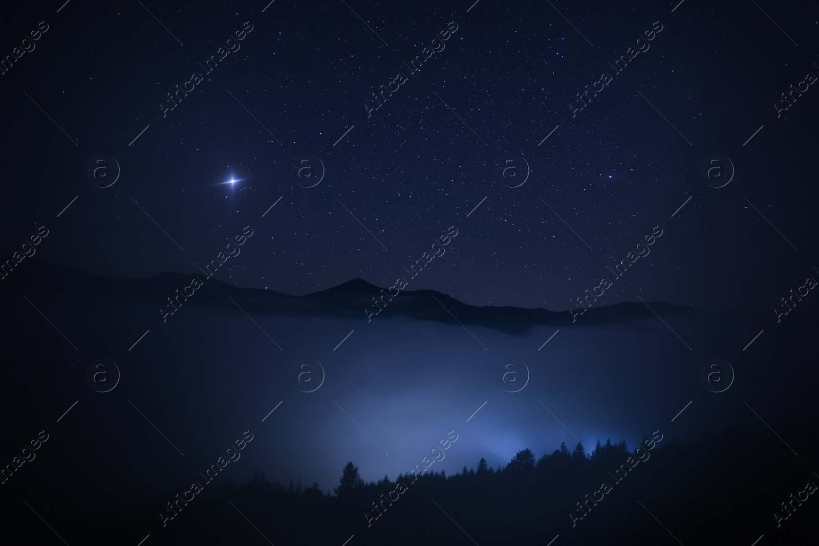 Photo of Beautiful view of misty mountains under starry sky at night